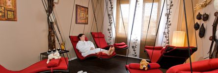 [Translate to english:] Im Ruheraum des Sauna- und Fitnessbereichs kann man sich auf von der Decke hängende Schwebeliegen entspannen.