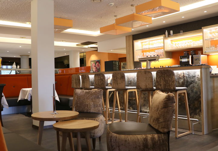 Blick in die Bar mit gemütlichen Barstühlen mit Samtbezügen 