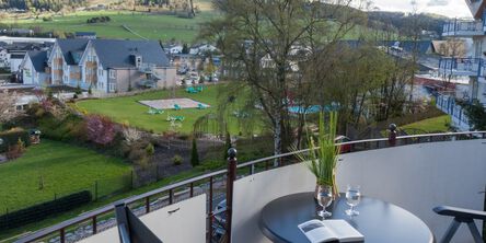 Südbalkon mit einem Tisch uns zwei Stühlen und Blick über die Landschaft 