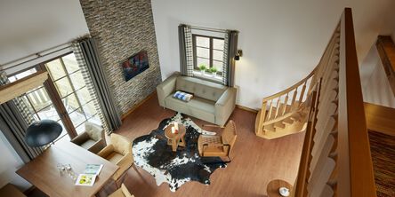Blick vom zweiten Stock in den modern eingerichteten Wohnbereich im Bergchalet