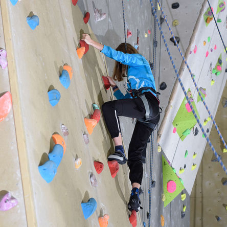Frau an einer Kletterwand