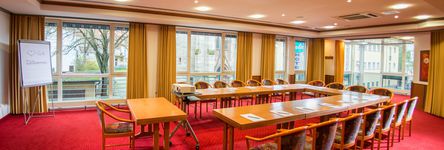 [Translate to english:] Tagungsraum Elisabeth mit u-förmiger Bestuhlung für 19 Personen, einem Beamer und einer Flipchart