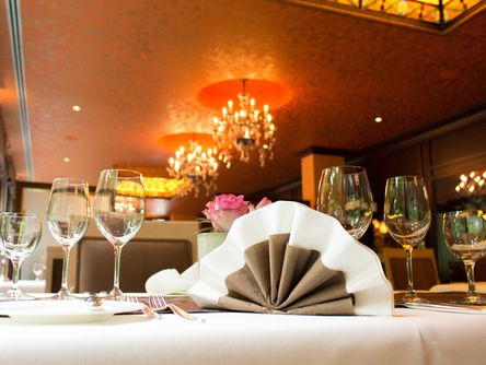 In Fächerform gefaltete Serviette auf einem gedeckten Tisch im Restaurant
