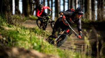 Zwei Mountainbiker fahren durch den Wald 