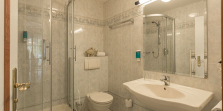 Hell gefliestes Badezimmer mit Dusche in der Villa Katharina