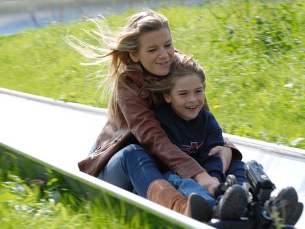 Mutter mit ihrem Kind auf der Sommerrodelbahn 